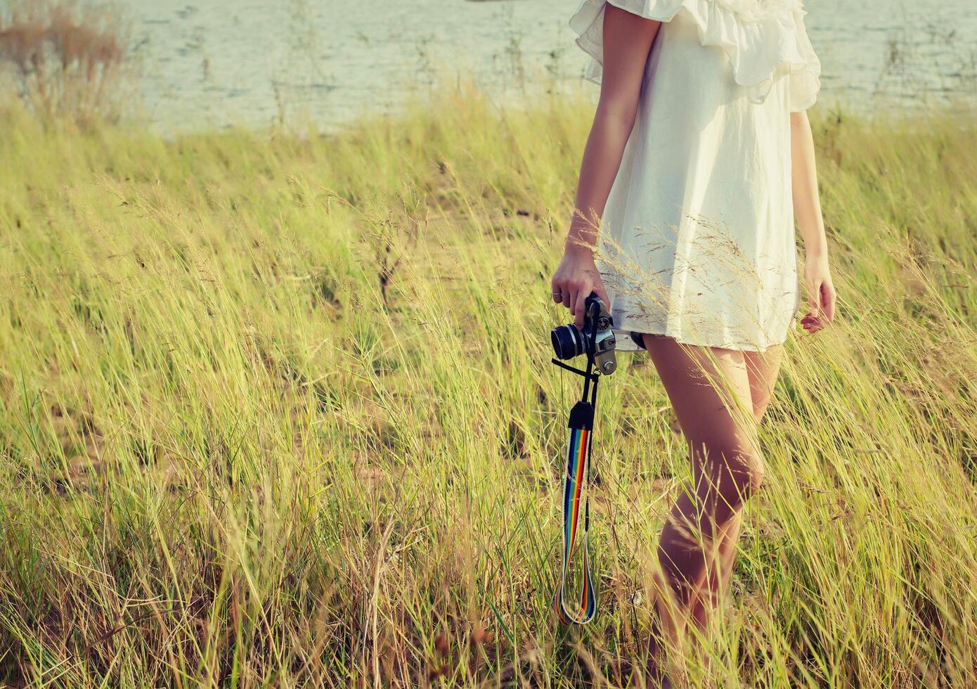 Beautiful woman photographer standing hand holding retro camera photo