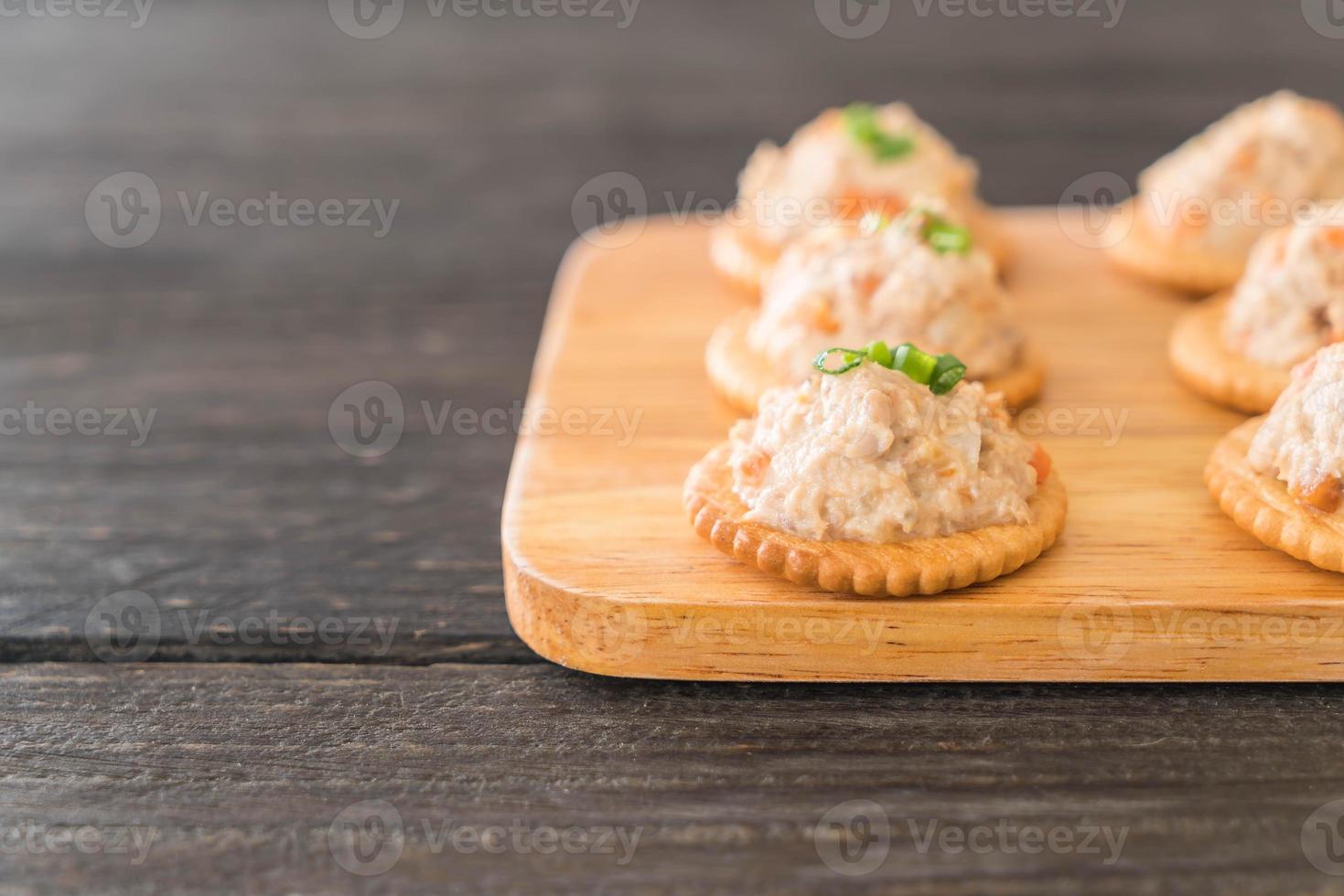 Tuna spread with cracker on wood board photo