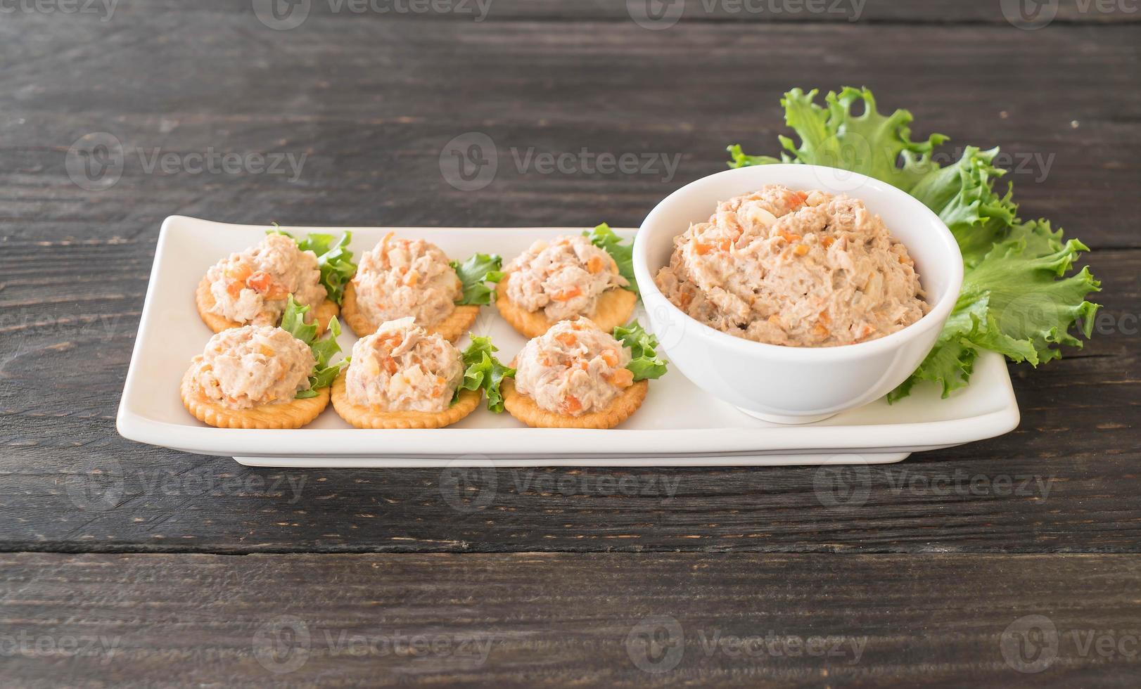 Tuna spread with cracker on wood board photo