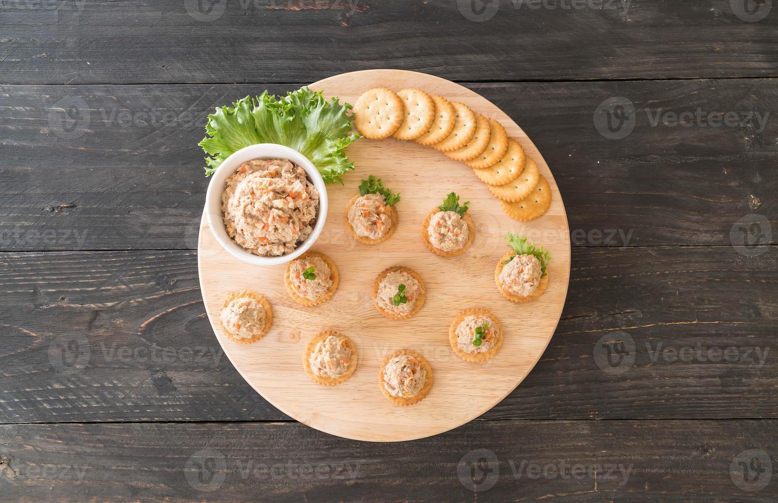 Tuna spread with cracker on wood board photo