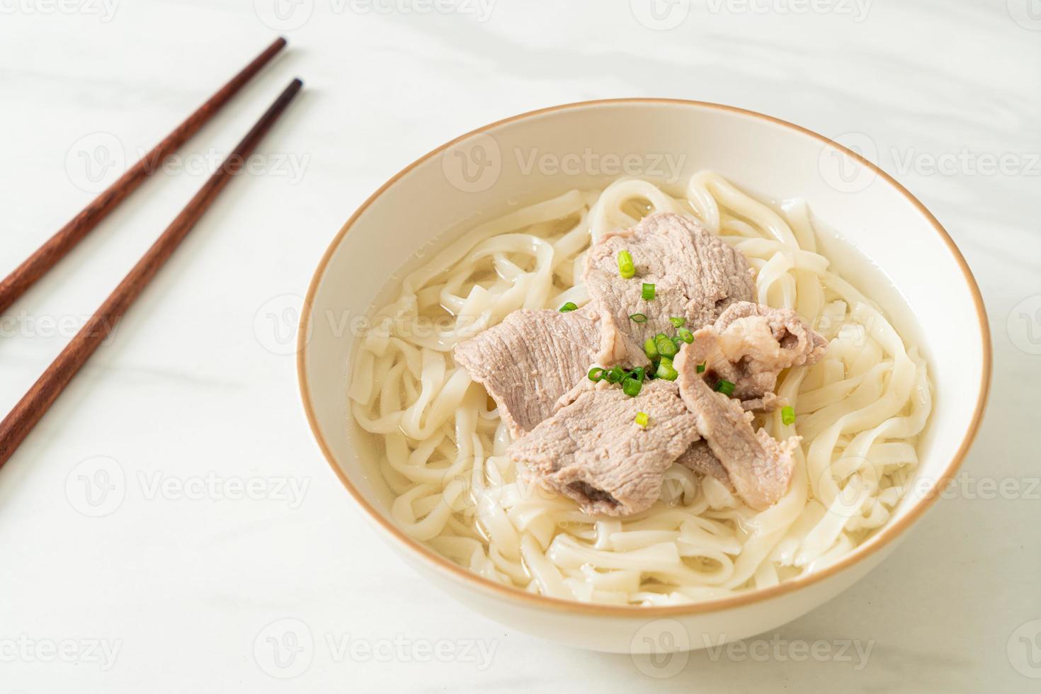 Fideos udon ramen caseros con carne de cerdo en sopa clara foto