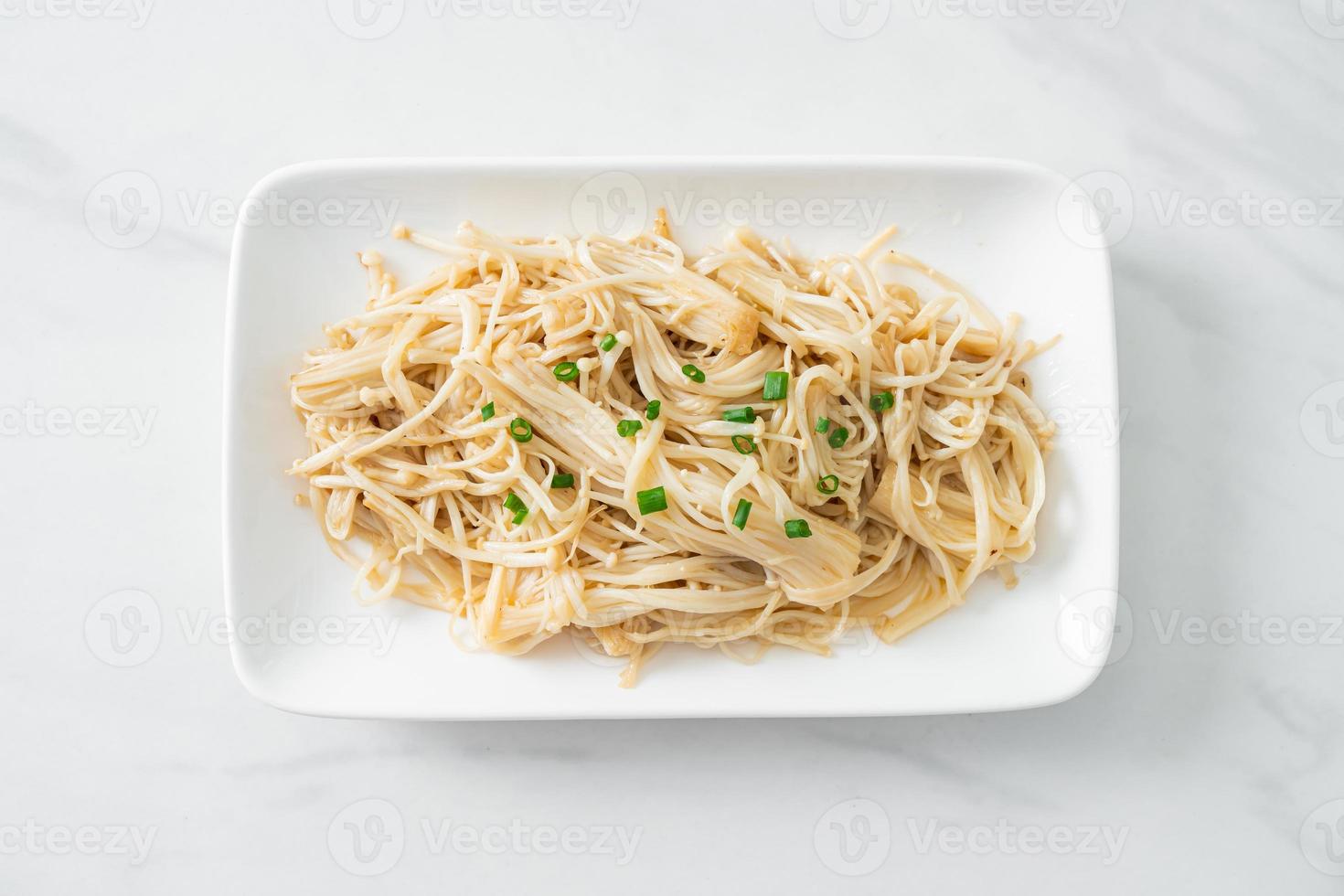 Setas de aguja doradas salteadas con mantequilla en la placa blanca. foto