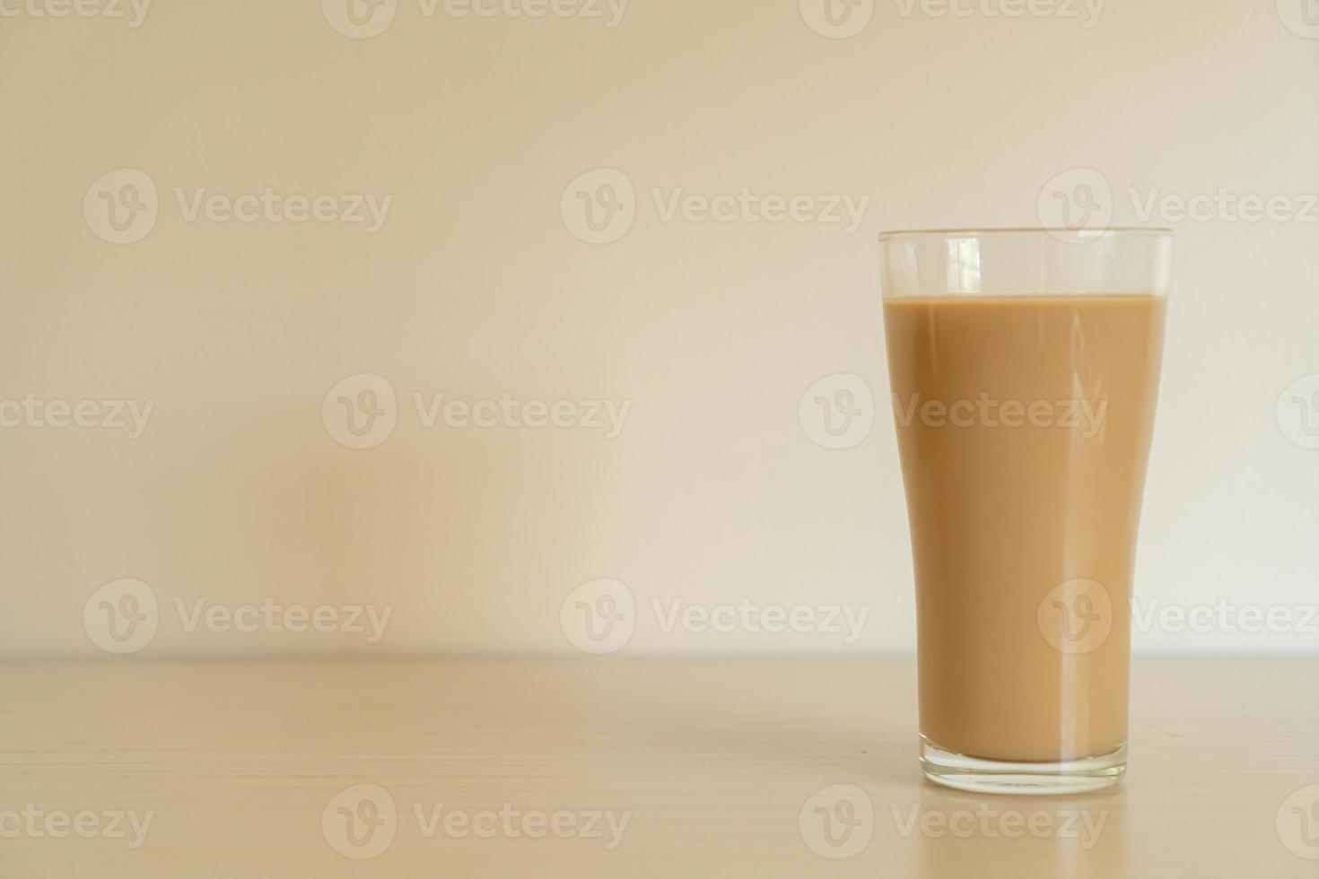 Vaso de café con leche con botellas de café listas para beber en la mesa foto