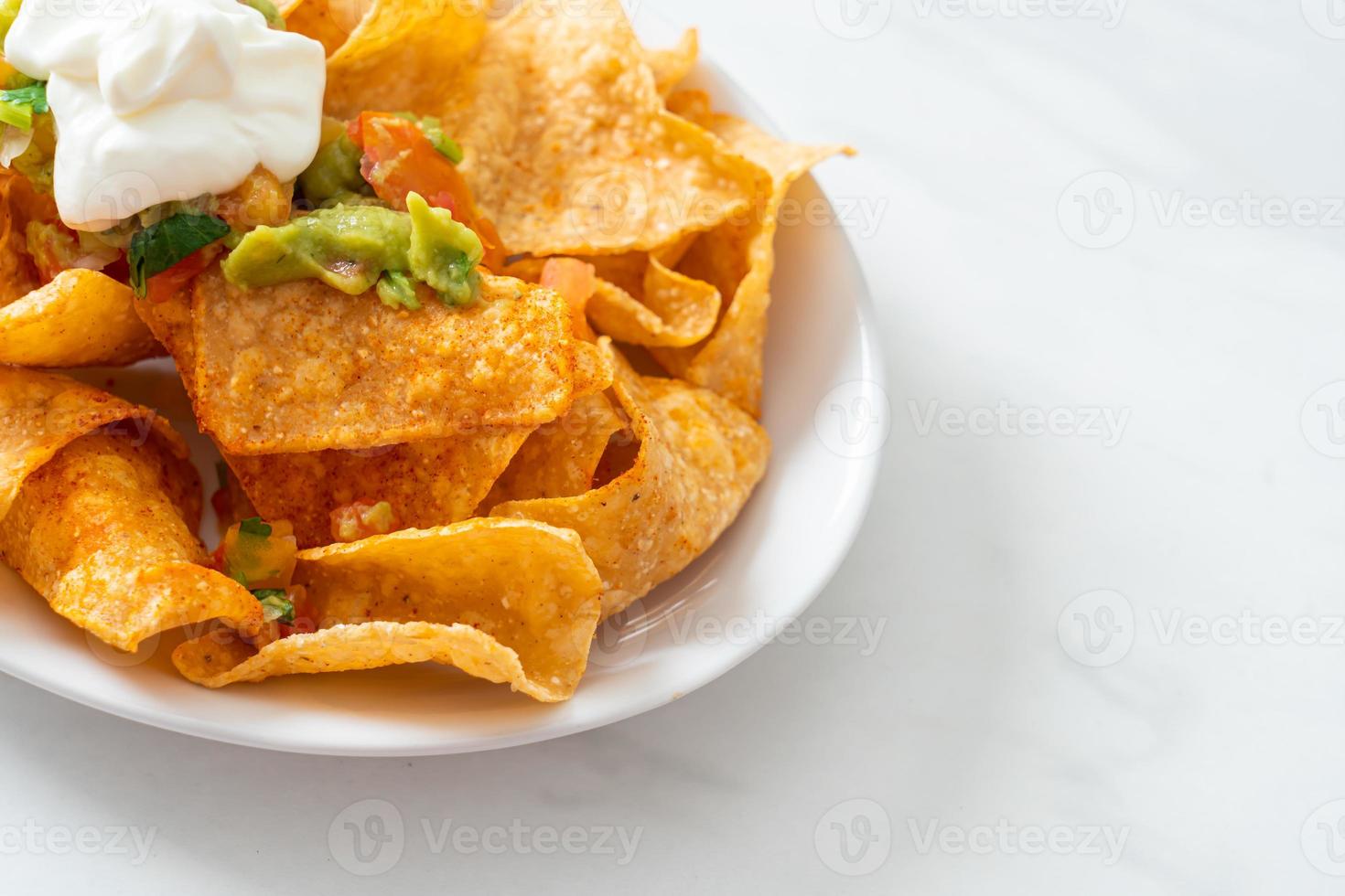 nachos mexicanos tortilla chips con jalapeño, guacamole, salsa de tomates y dip foto