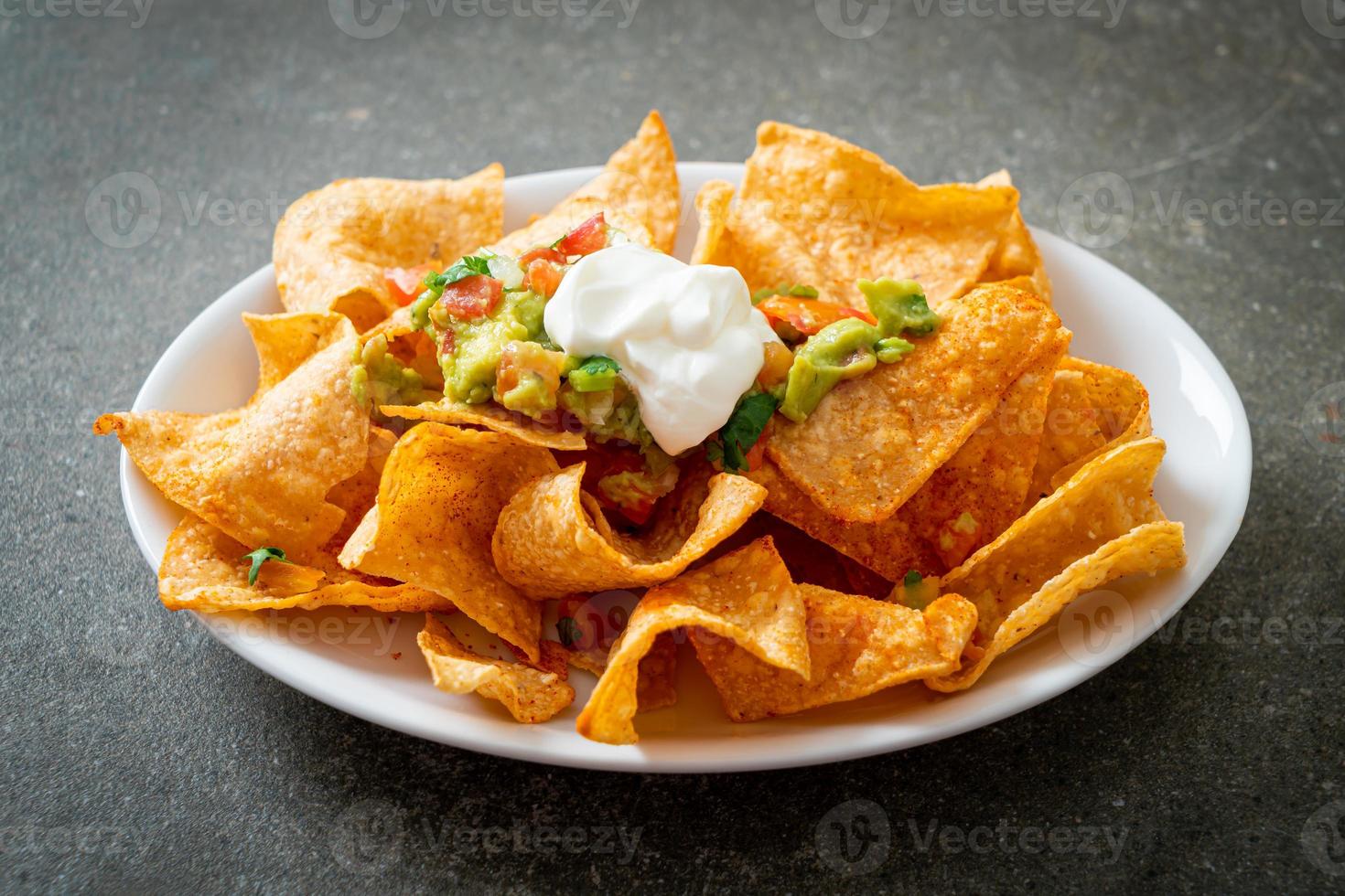 nachos mexicanos tortilla chips con jalapeño, guacamole, salsa de tomates y dip foto