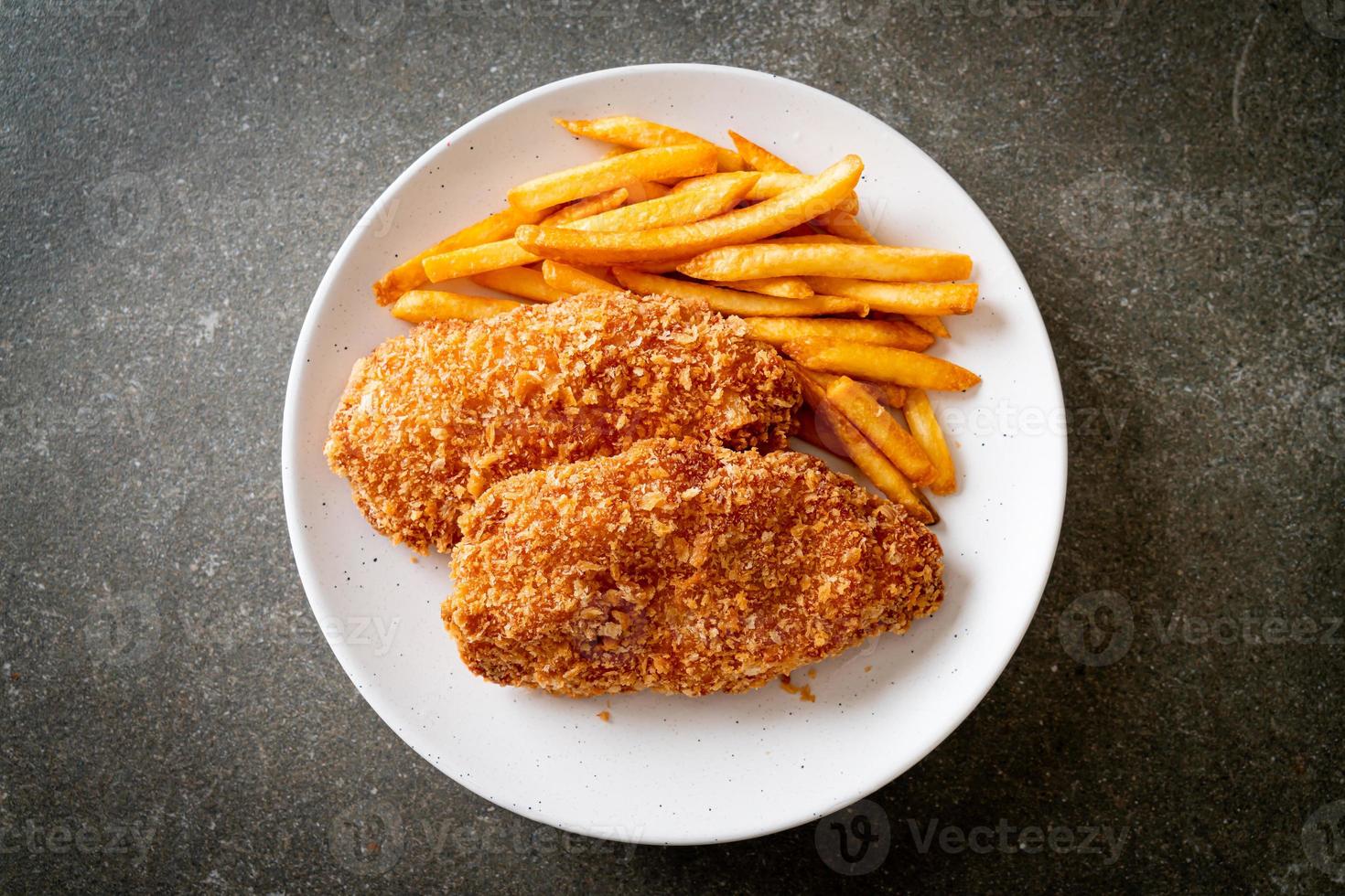 Filete de pechuga de pollo frito con papas fritas y salsa de tomate foto