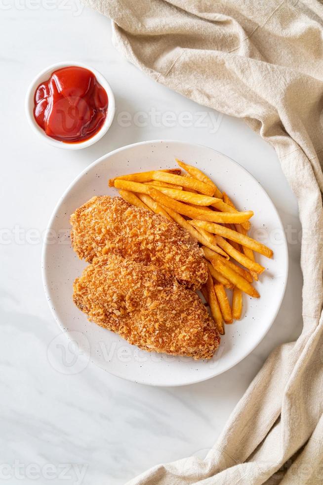 Filete de pechuga de pollo frito con papas fritas y salsa de tomate foto