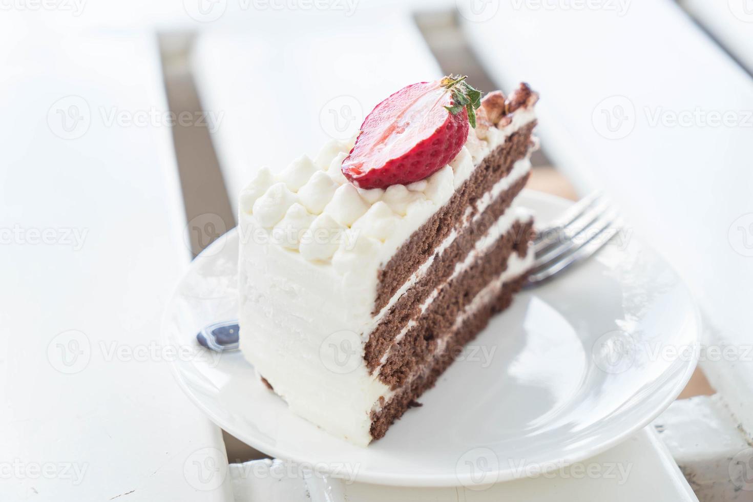 Tarta de vainilla y chocolate con fresa en cafe foto