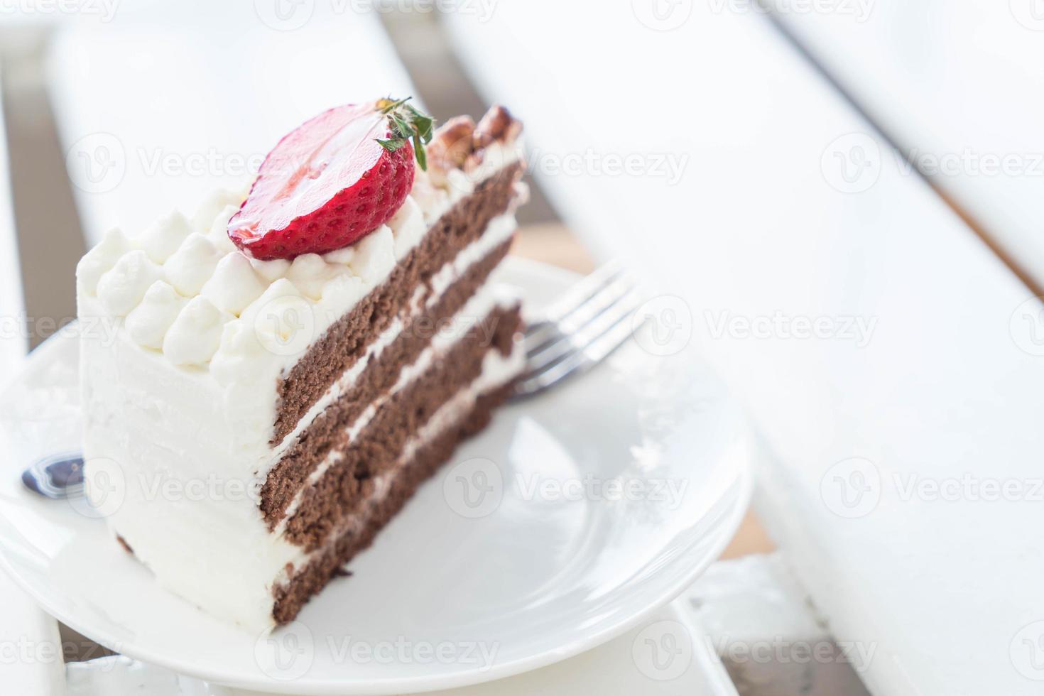 Tarta de vainilla y chocolate con fresa en cafe foto