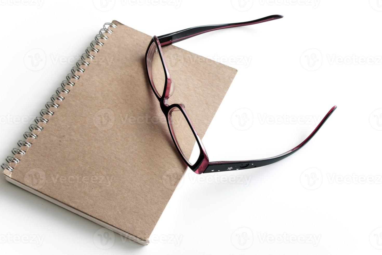 Blank page of a notebook and eyeglasses photo