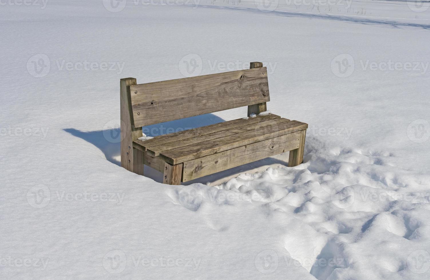 banco de madera en la nieve del invierno foto