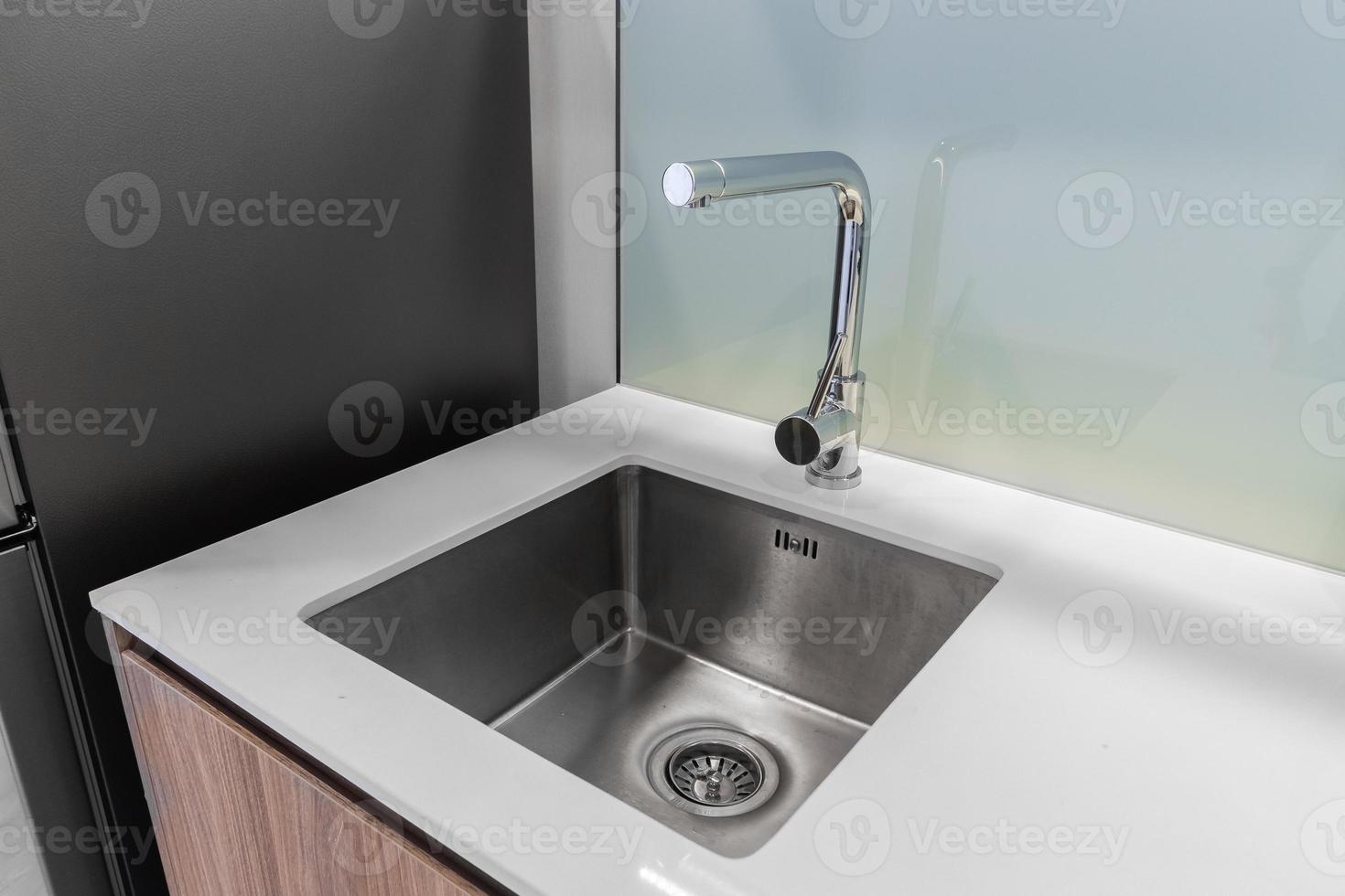 Clean stainless steel sink in with counter tops photo