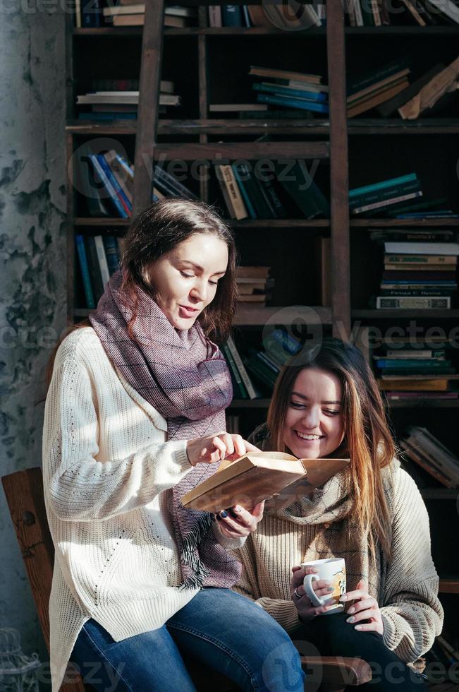 Cute student friends reading books together having fun photo