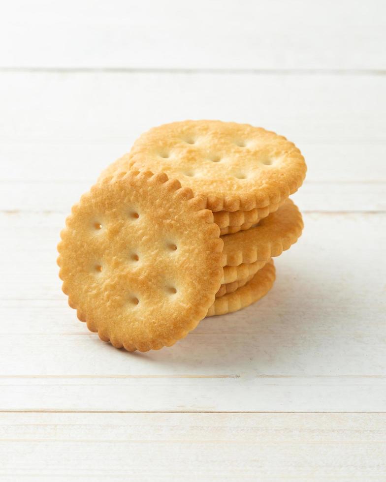 Rounded Cracker cookies on white wooden table background photo