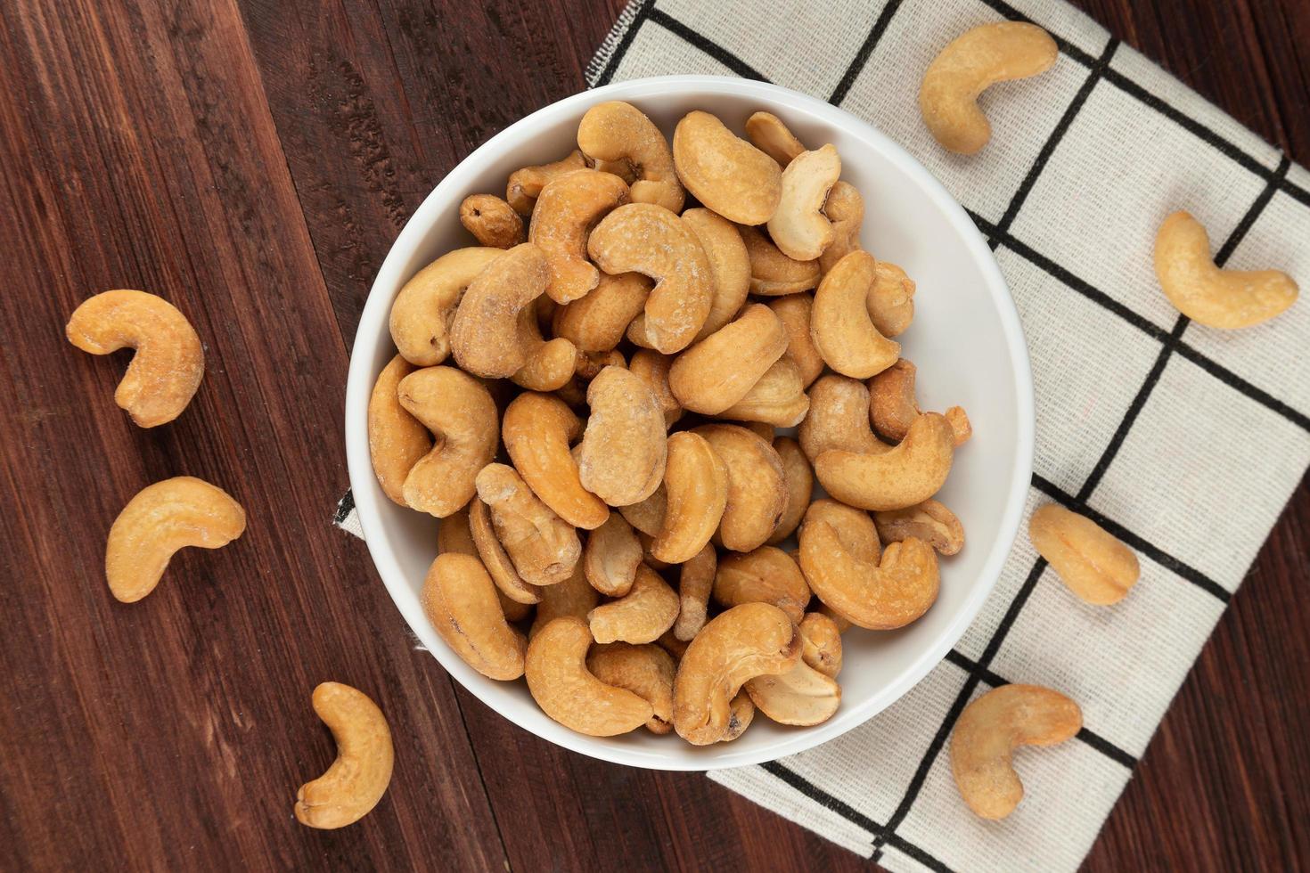 Top view of cashew nuts in white bowl on the table, Flat lay photo