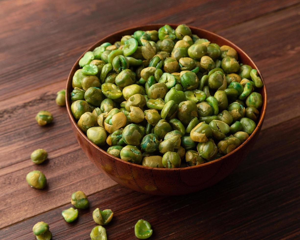 Salted green peas in wooden bowl on the table photo