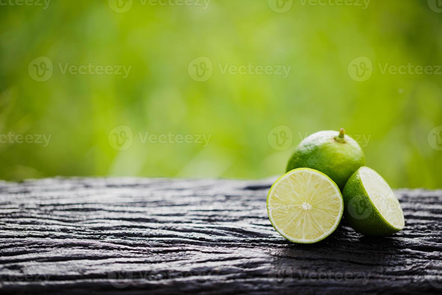 limón verde cortado en madera foto