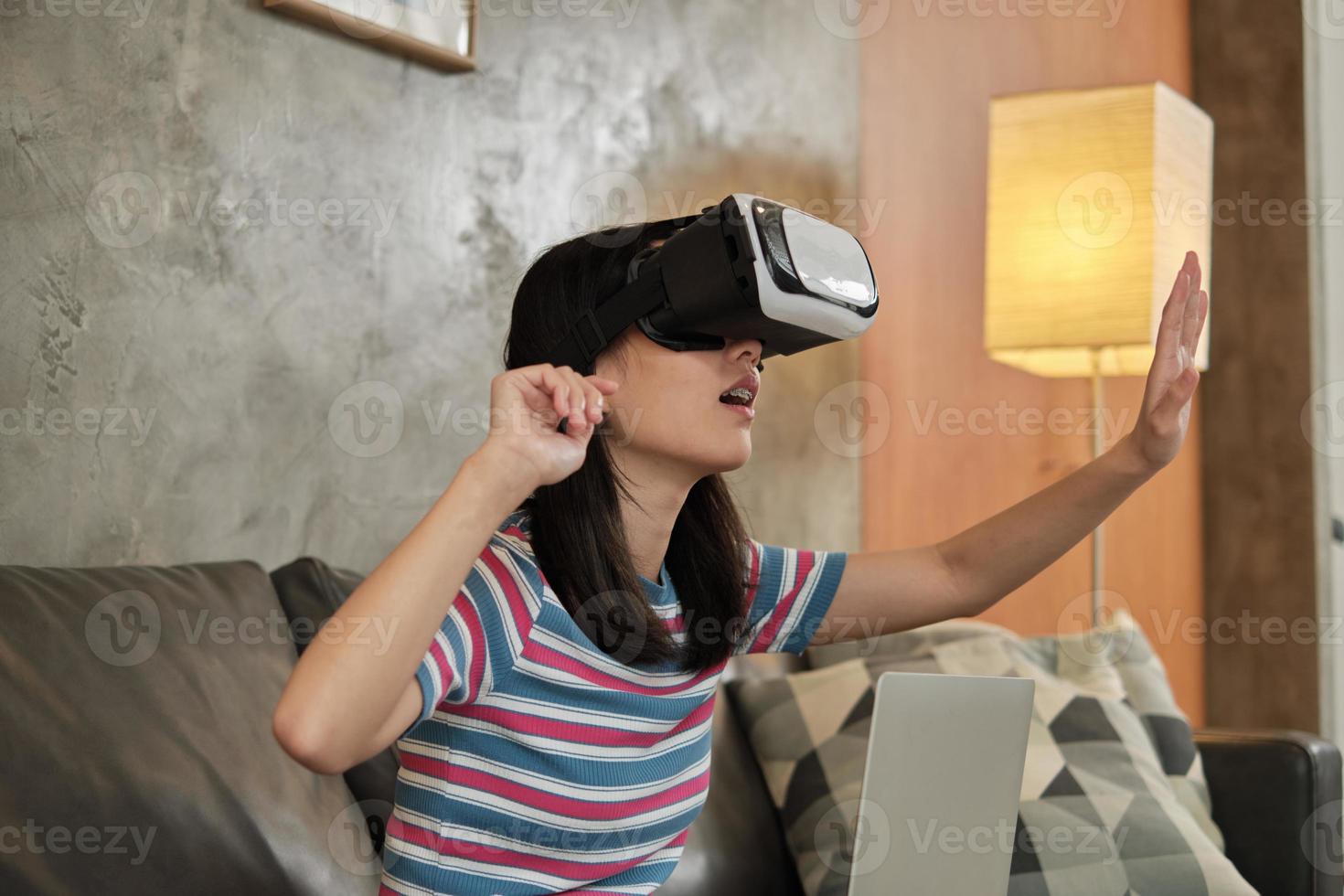 mujer asiática con auriculares vr, viendo la simulación virtual 3d. foto