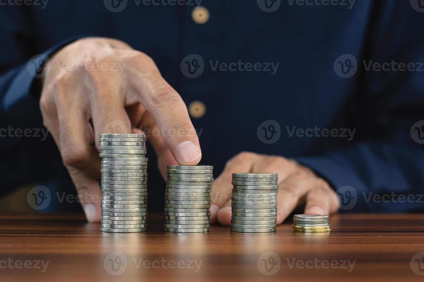 Hand counting coins stack on wooden table photo