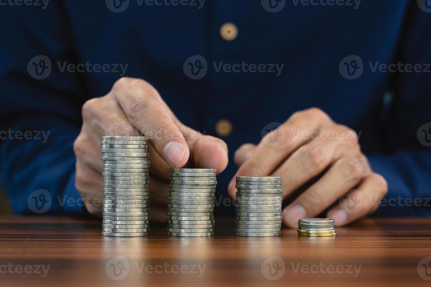 Hand counting coins stack on wooden table photo