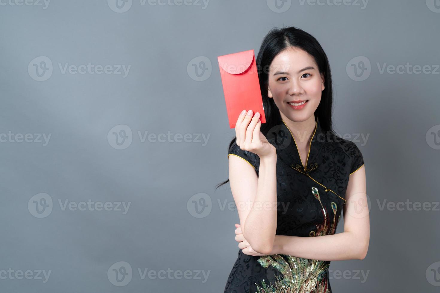 Mujer asiática vistiendo traje tradicional chino con paquete rojo foto