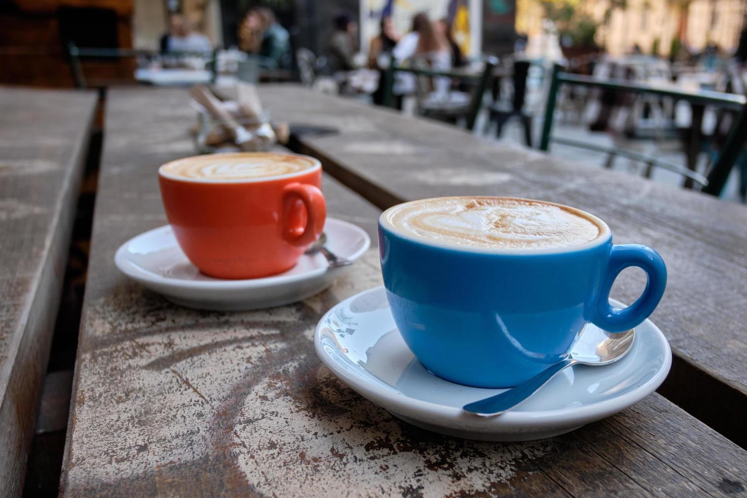 Primer plano de dos tazas de café con leche en una superficie de madera foto