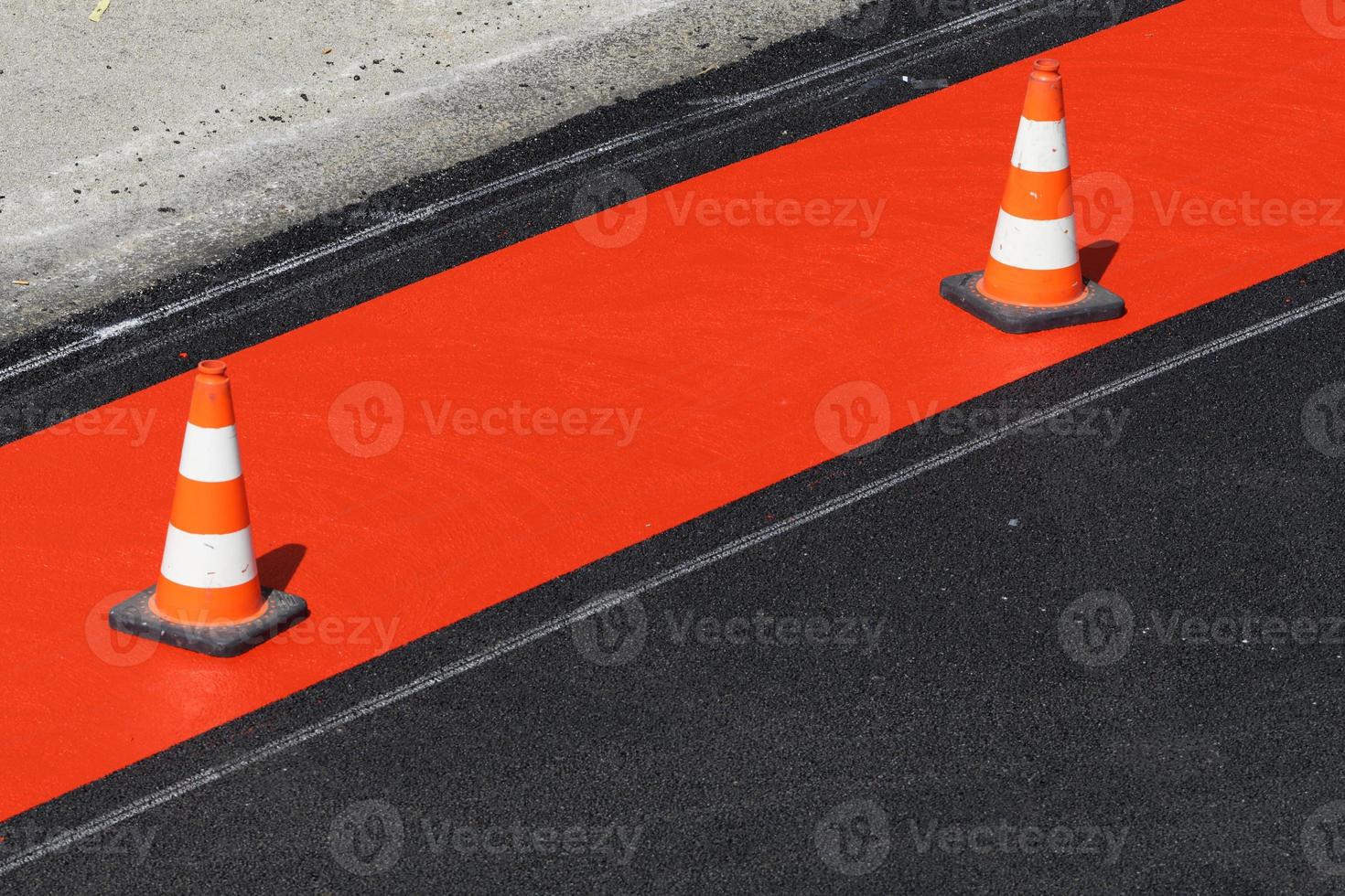 Pilones rojos y blancos en una pista para bicicletas recién marcada en rojo foto