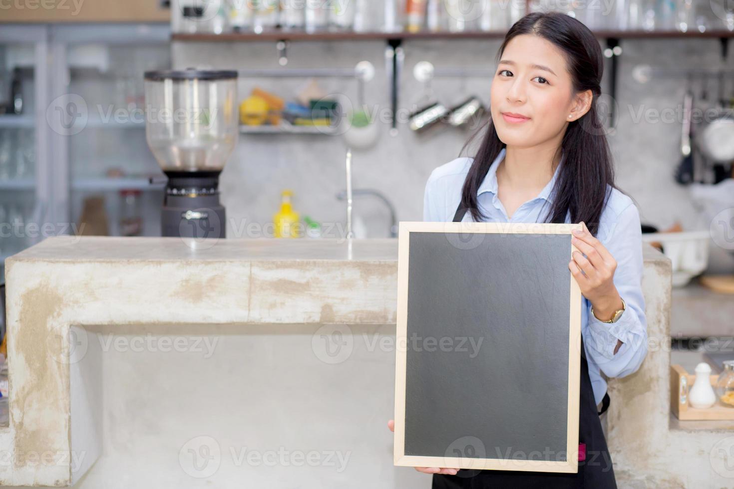 Asian woman is a employee standing holding chalkboard photo