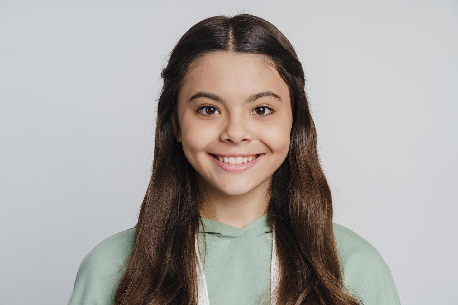 Cute, attractive teenage girl smiling on a white background photo