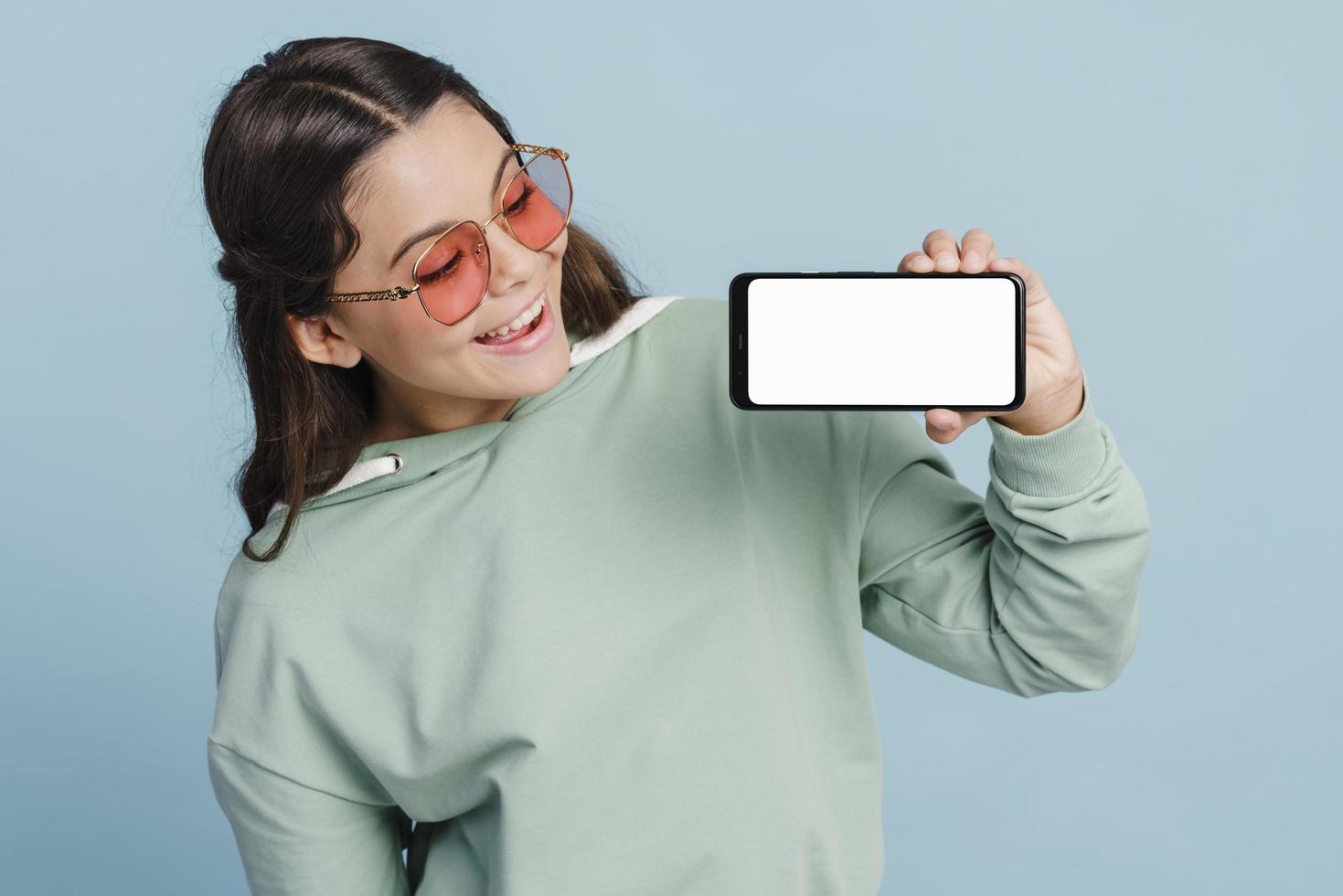 Pretty teenage girl holding a smartphone in her hands photo