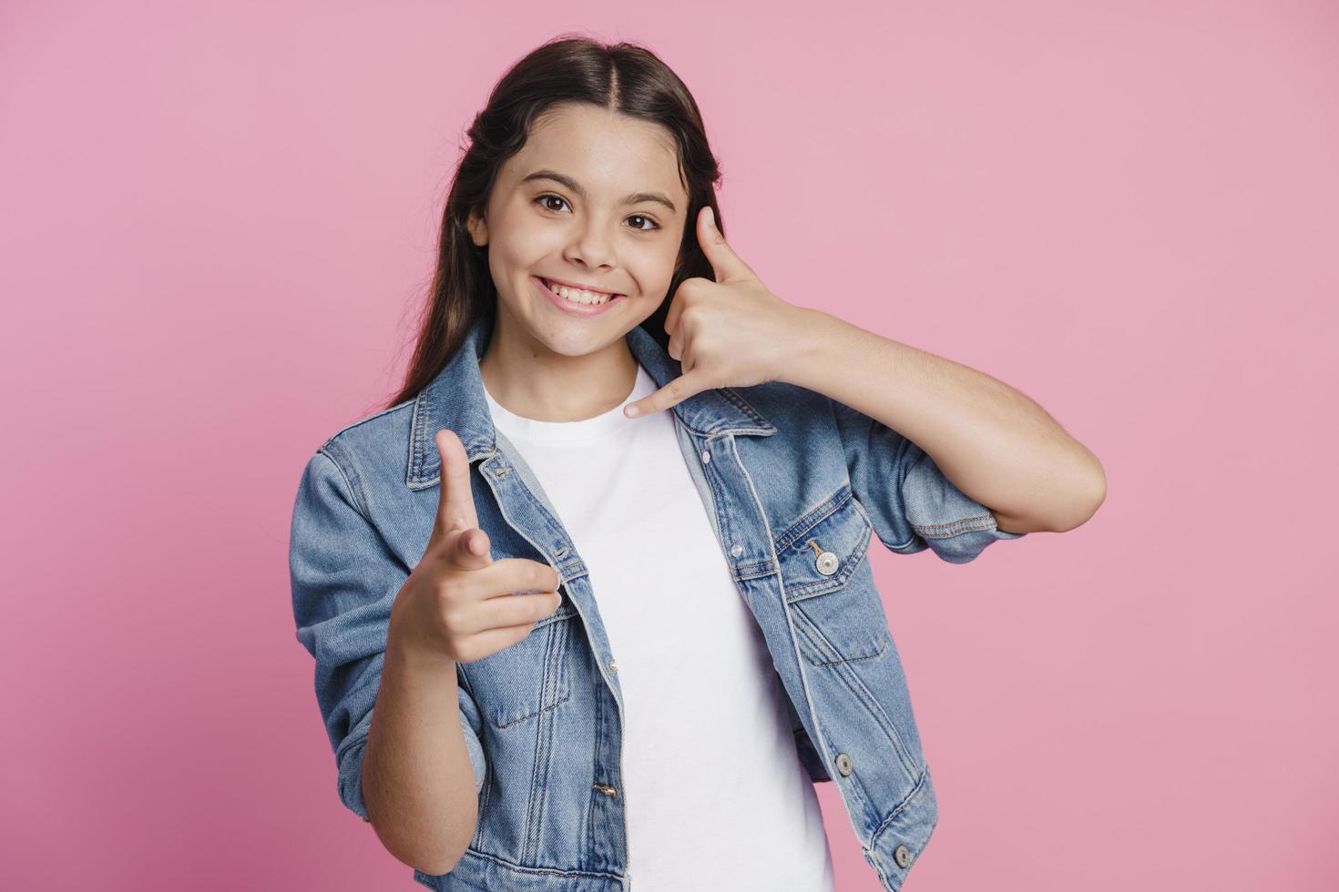 Teen girl shows a gesture to call back, points a finger photo