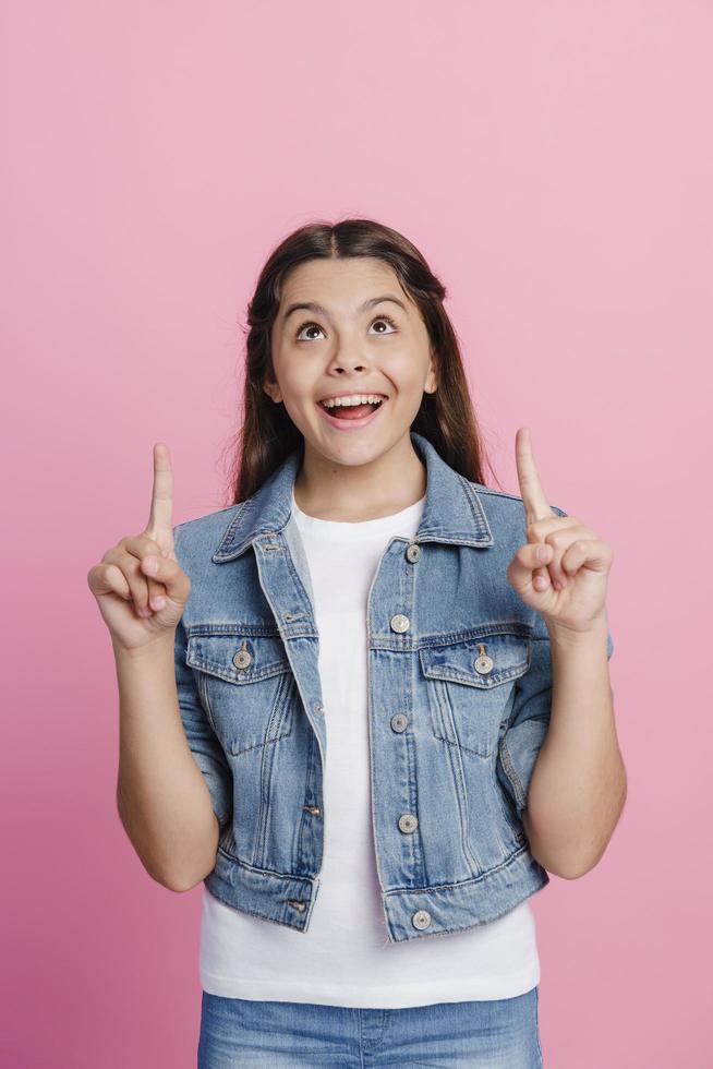 Smiling girl shows index fingers up photo