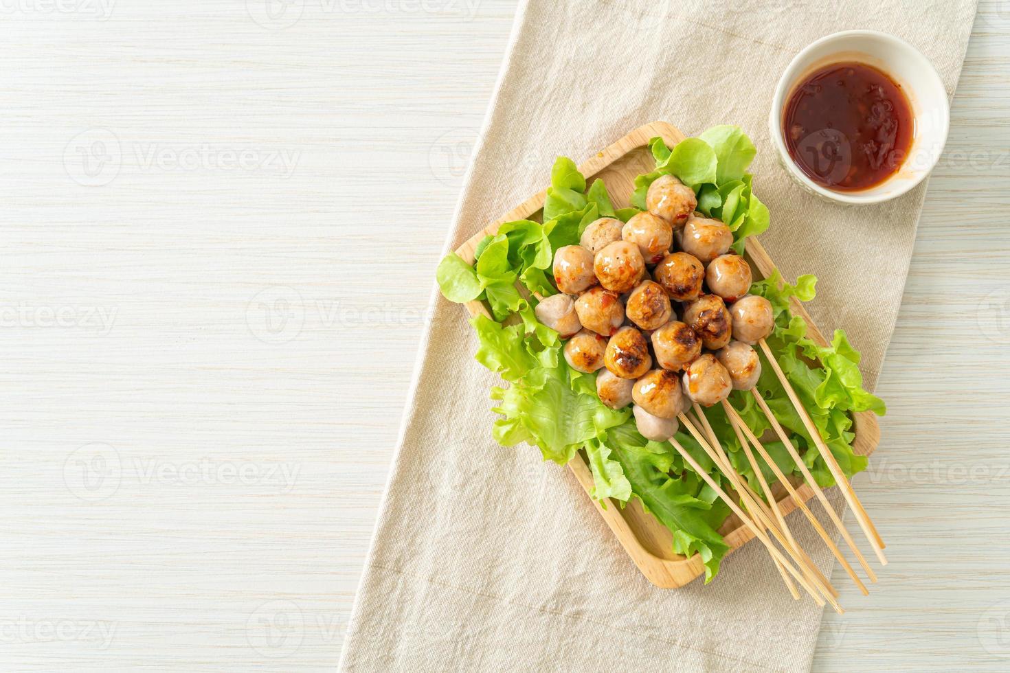 Grilled meatballs skewer with spicy dipping sauce photo