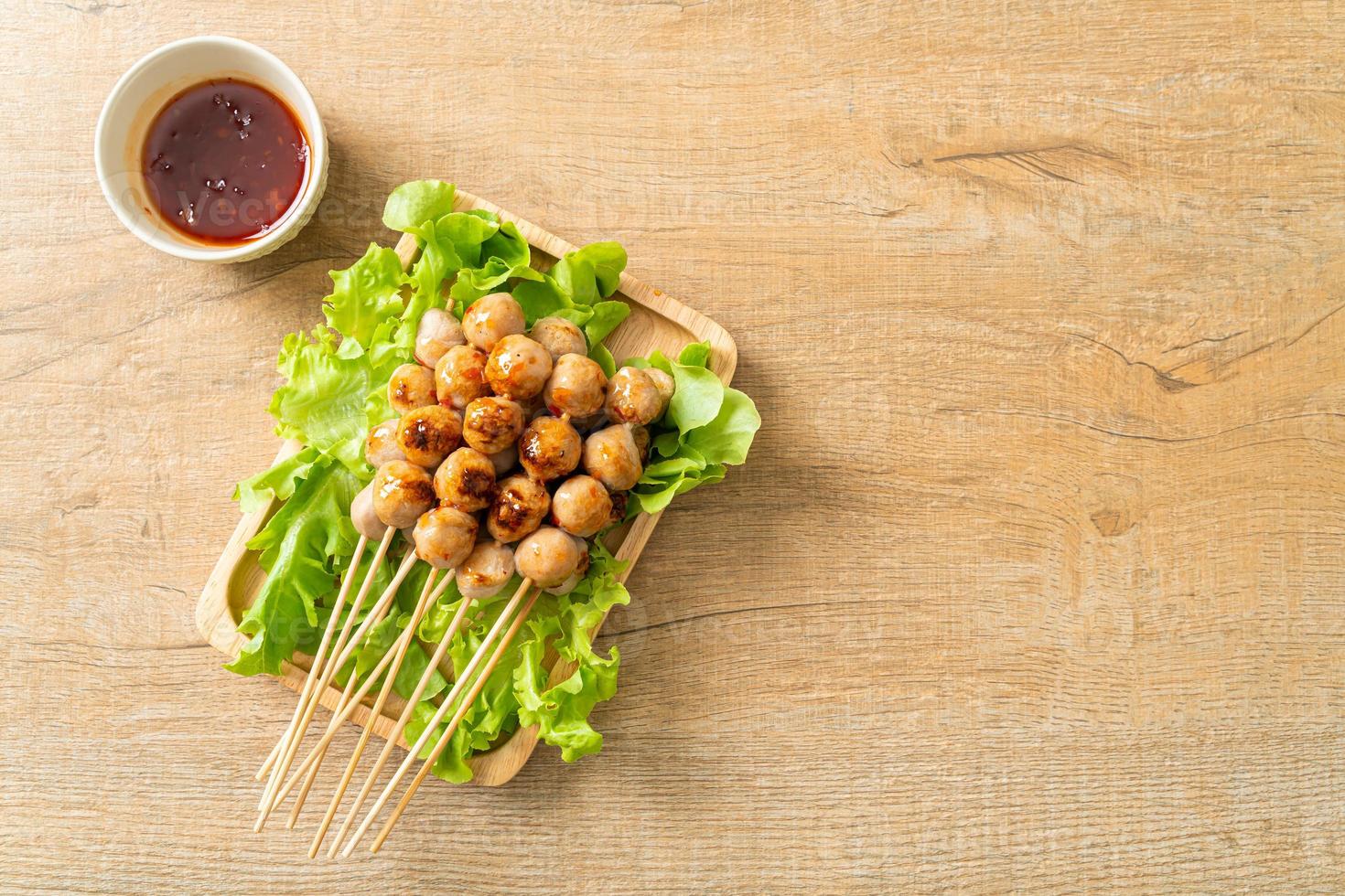 Grilled meatballs skewer with spicy dipping sauce photo