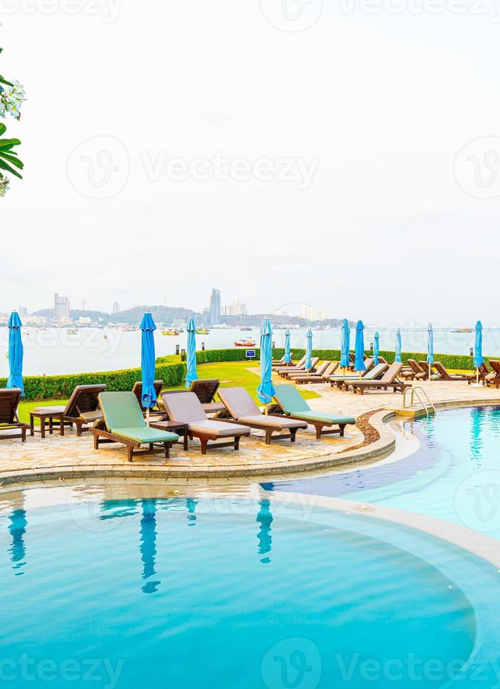 Piscina de silla o piscina de cama y sombrilla alrededor de la piscina con fondo de playa de mar en Pattaya en Tailandia foto