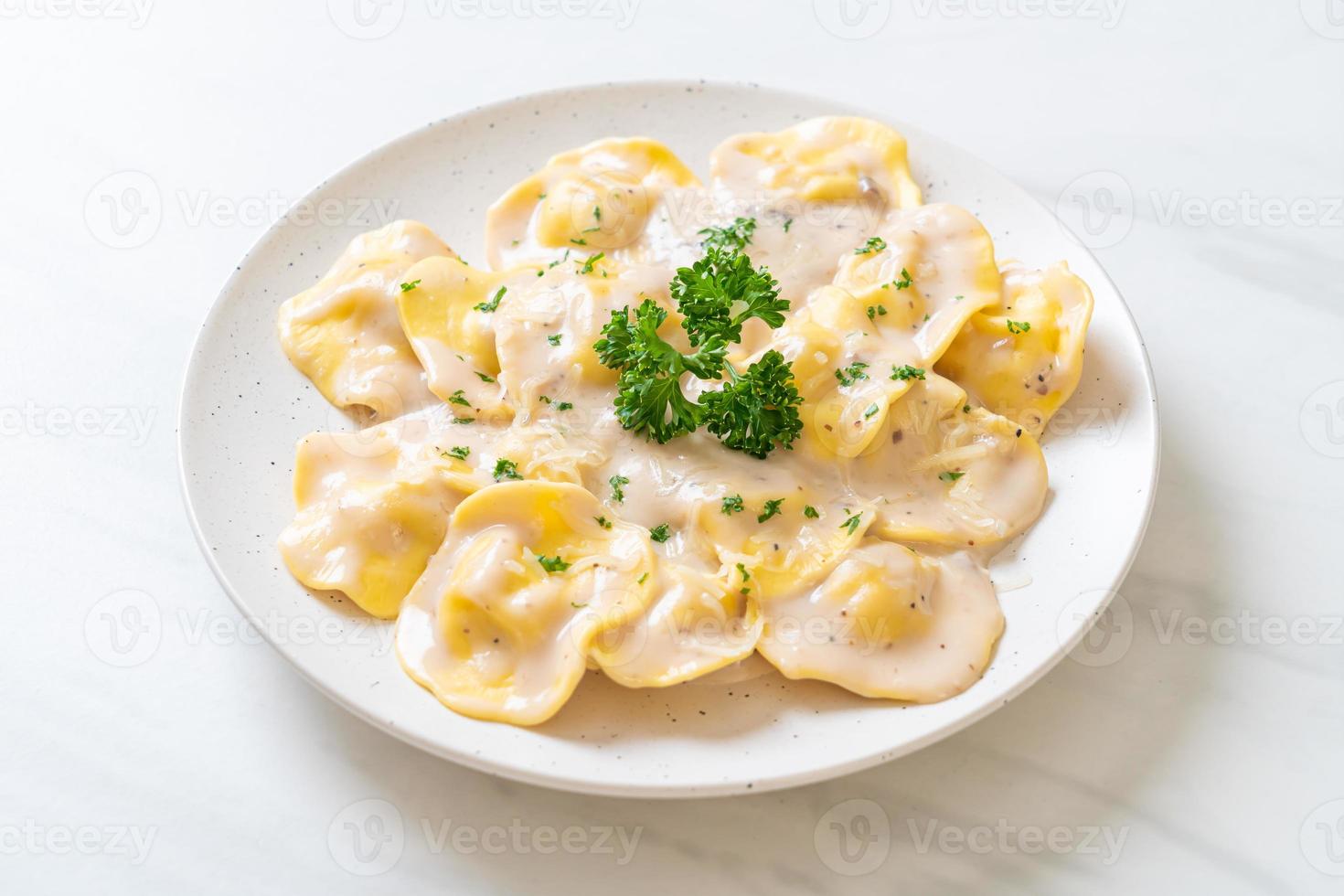 Ravioli pasta with mushroom cream sauce and cheese - Italian food style photo