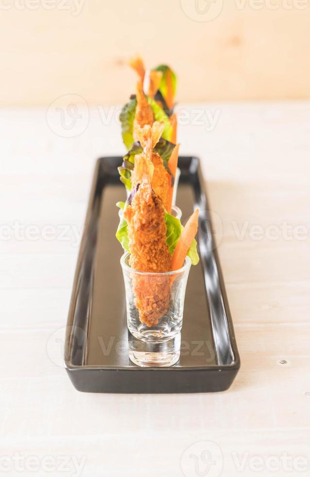 Batter-fried prawns on a black plate photo