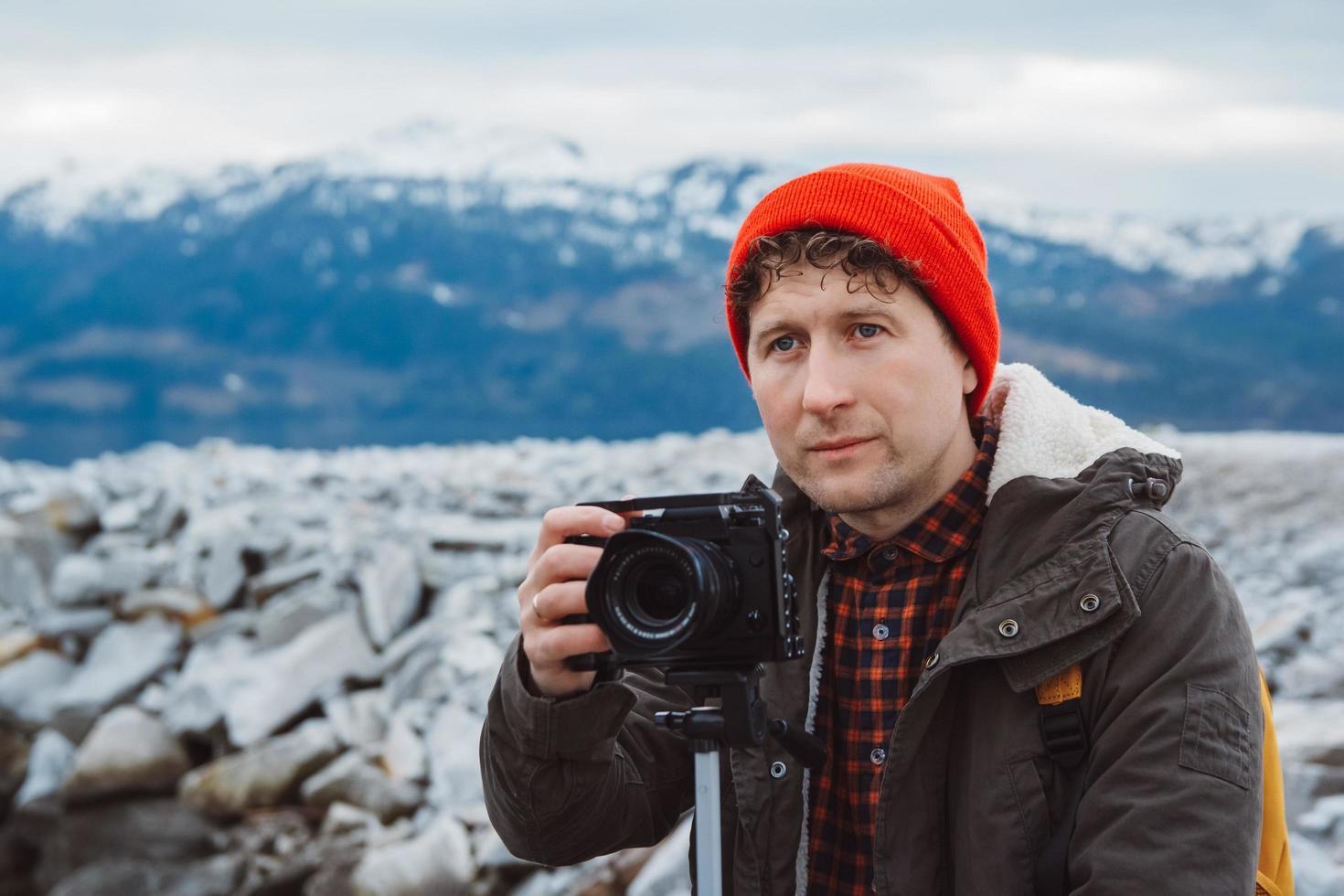 Videographer on adventure vacation shooting camera on tripod photo