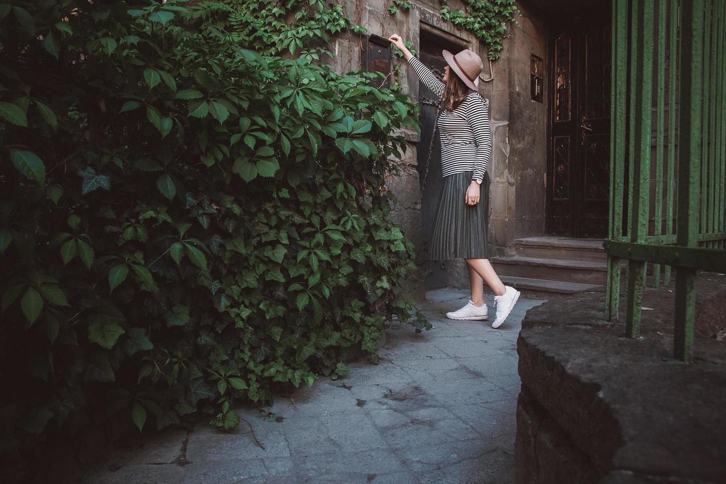 Girl in hat opens a mailbox at the background of the old house photo