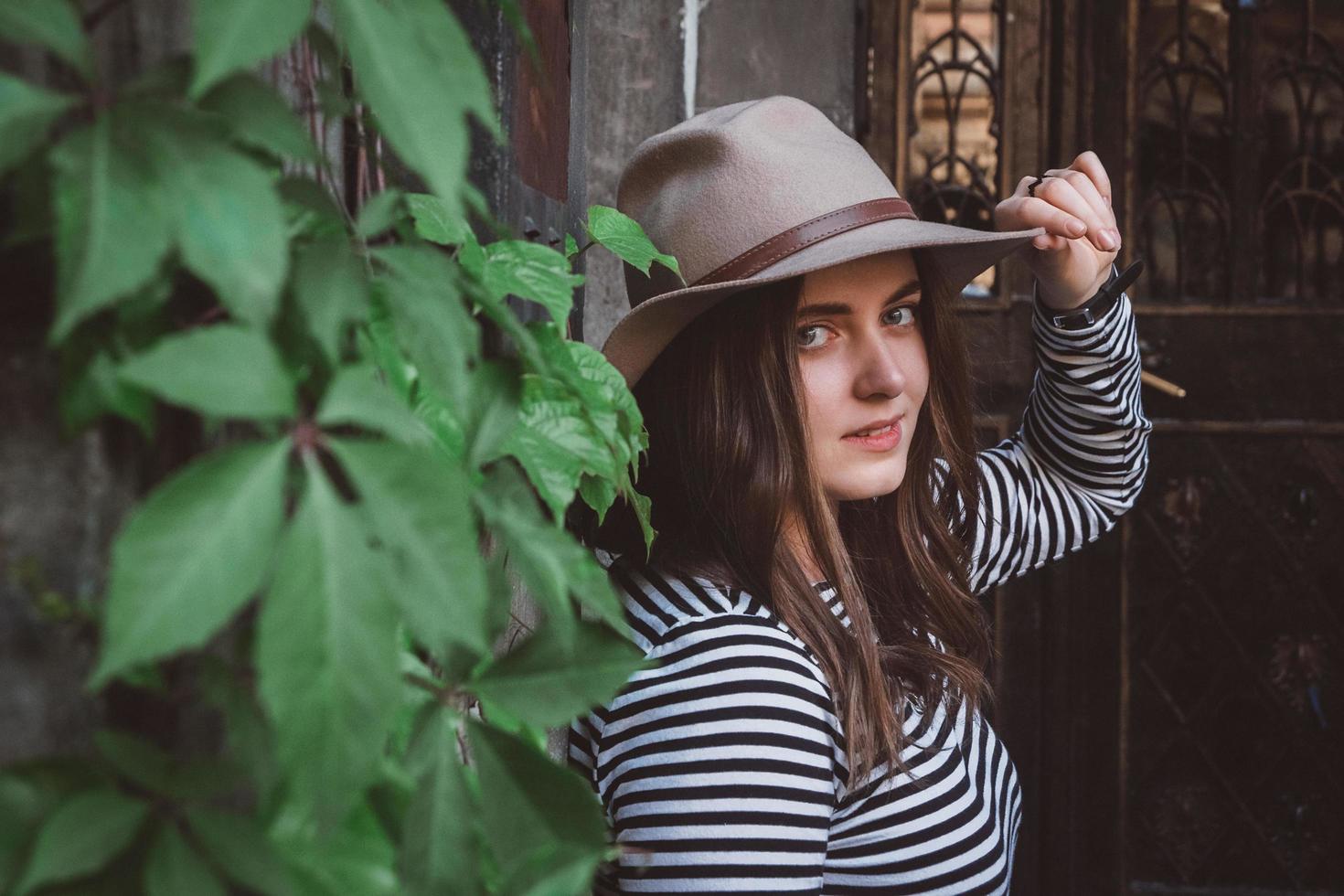 hermosa mujer en una camisa a rayas sosteniendo su sombrero foto