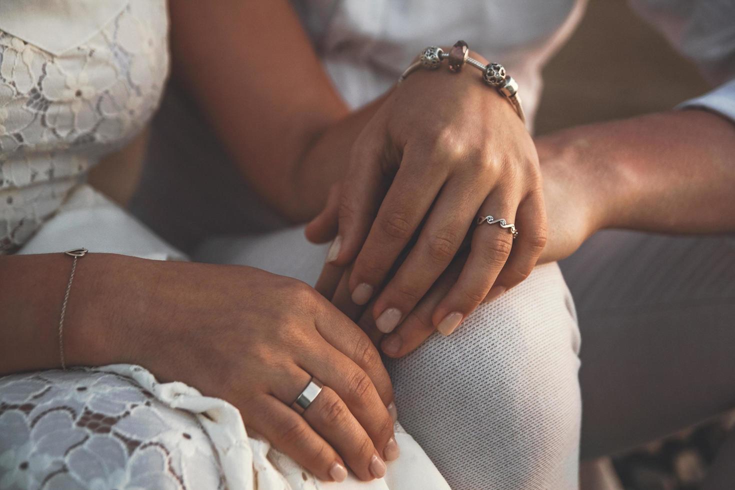 novios tomados de la mano en la puesta del sol foto