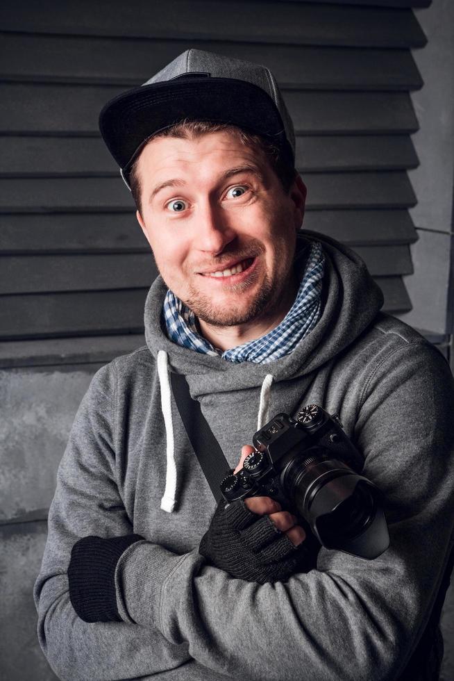 Man is a photographer with camera. Funny Face. Dark gray background photo