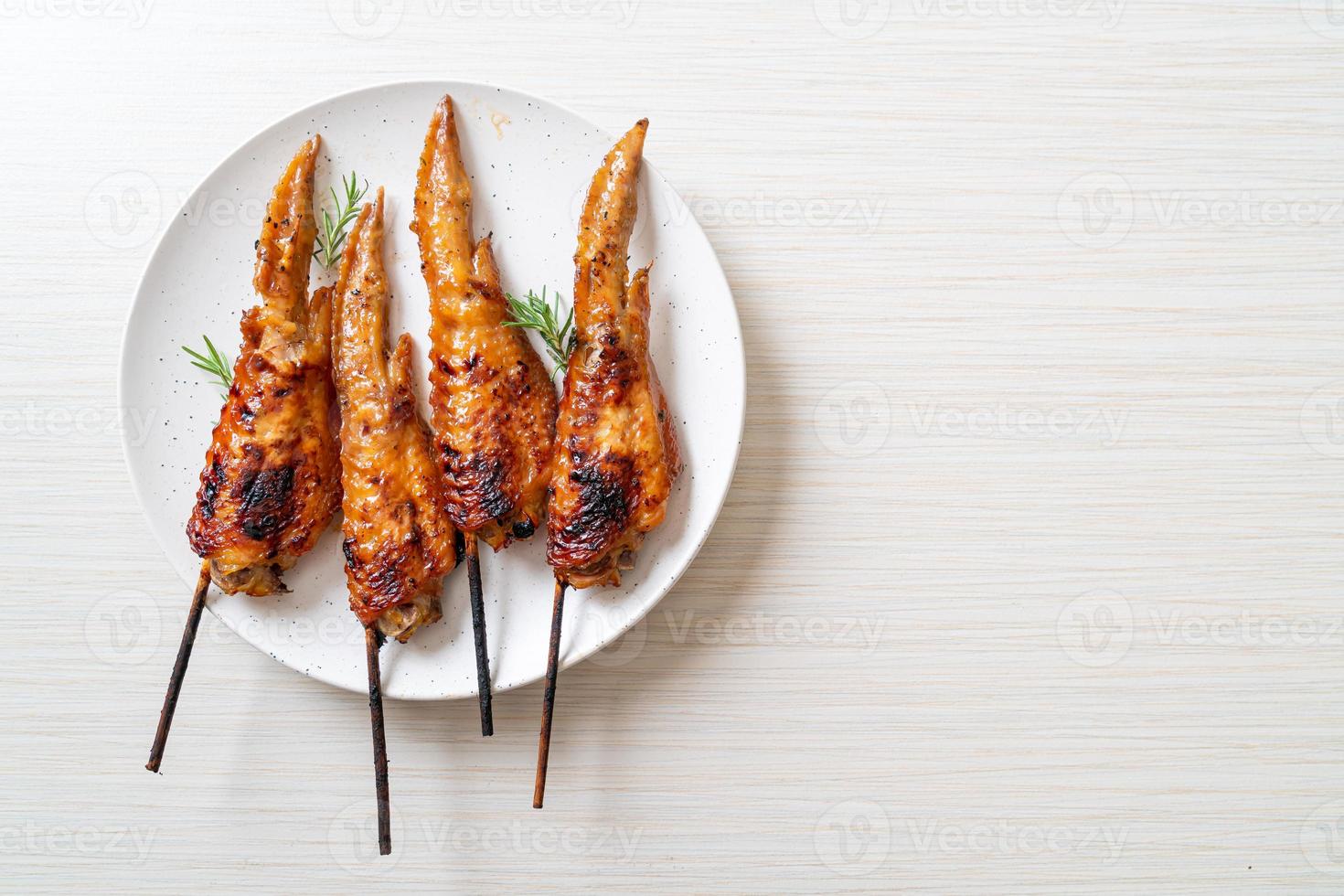 Grilled or barbecue chicken wings skewer on plate photo