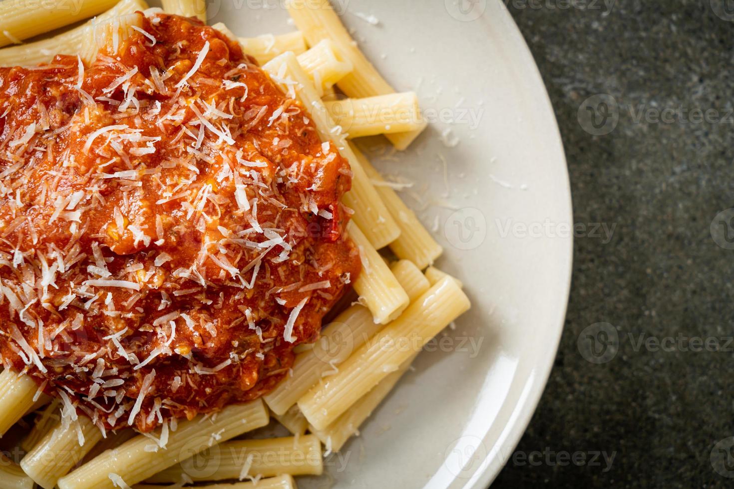 Rigatoni pasta with pork bolognese sauce - Italian food style photo