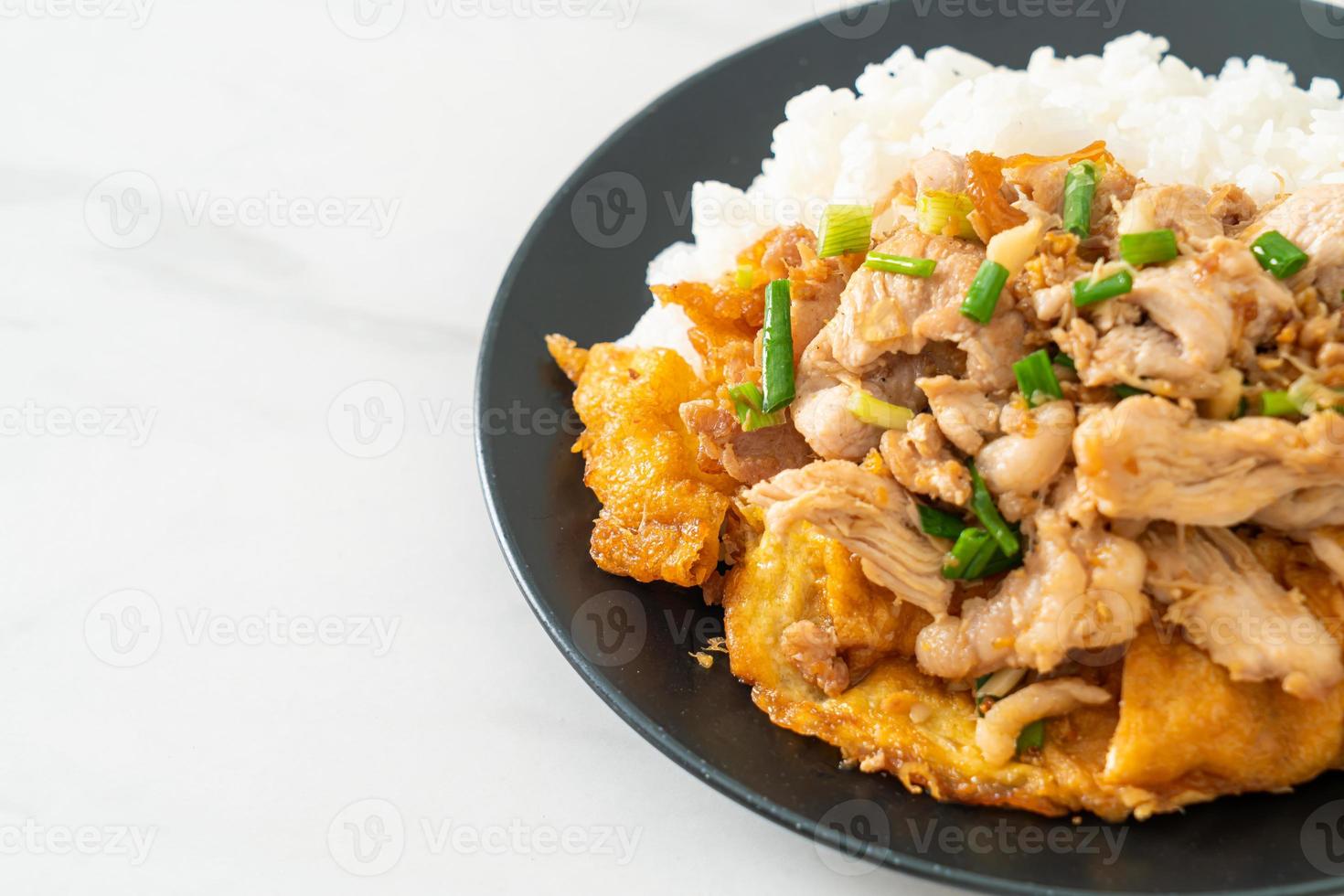 Stir-fried pork with garlic and egg topped on rice - Asian food style photo