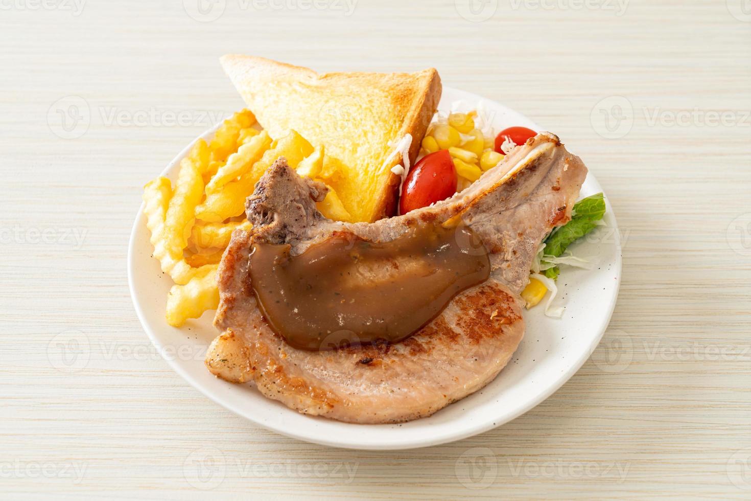 Pork chop steak with chips and mini salad on white plate photo