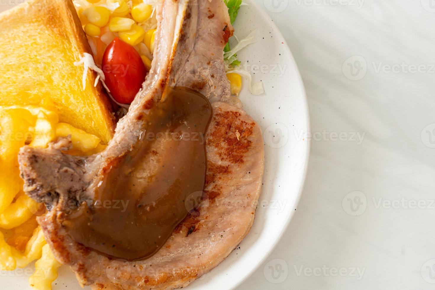 Pork chop steak with chips and mini salad on white plate photo