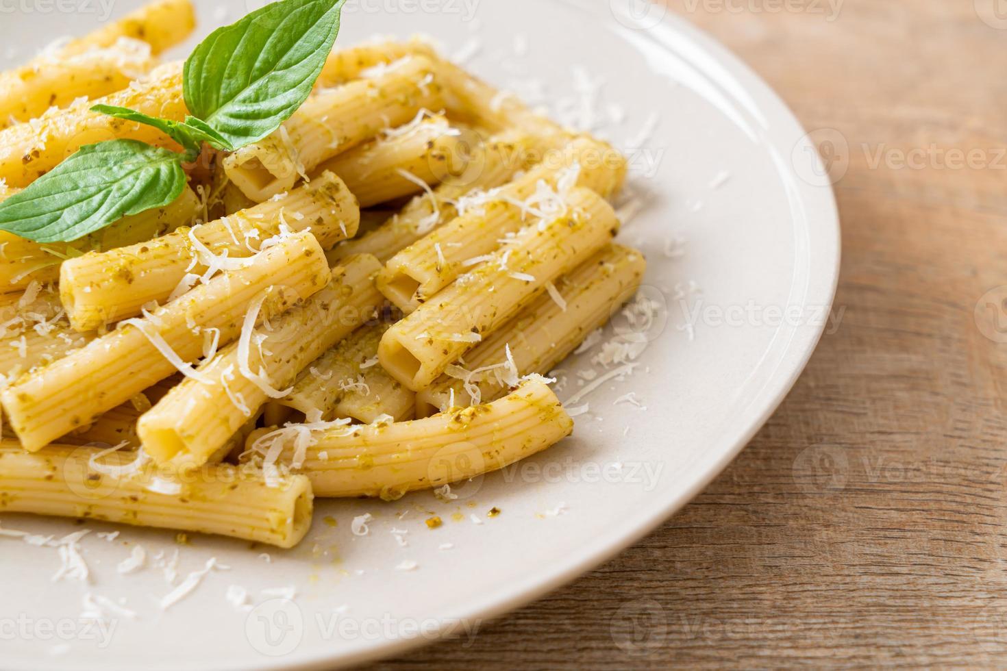 Pesto Rigatoni pasta with parmesan cheese - Italian food and vegetarian food style photo