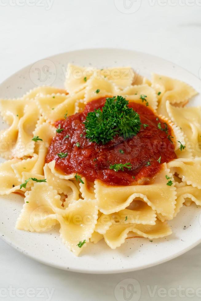 Pasta farfalle en salsa de tomate con perejil - estilo de comida italiana foto