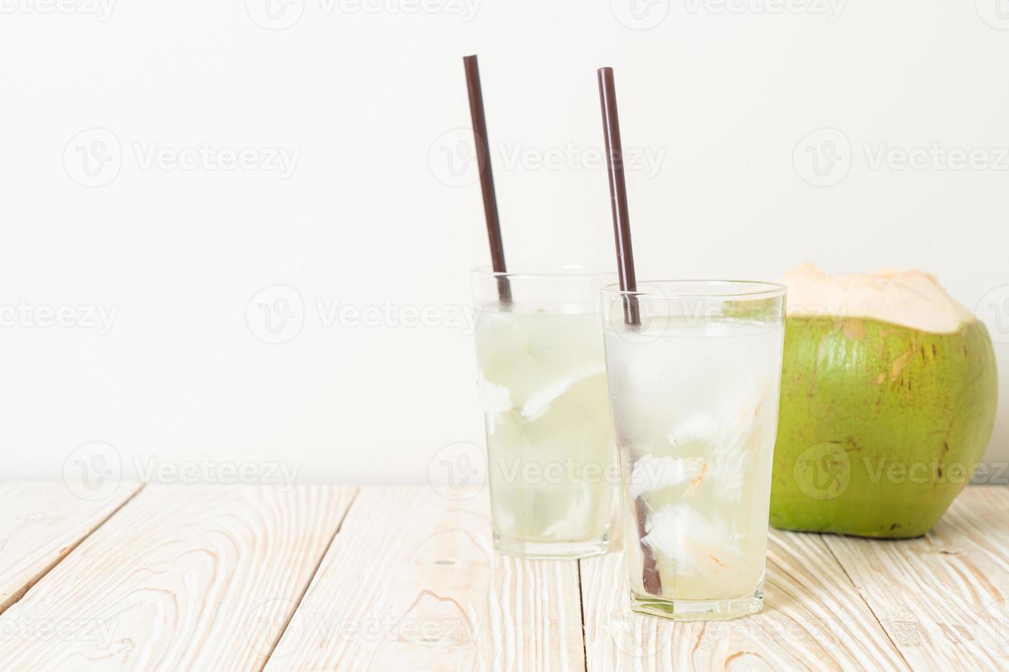 Coconut water or coconut juice in glass with ice cube photo